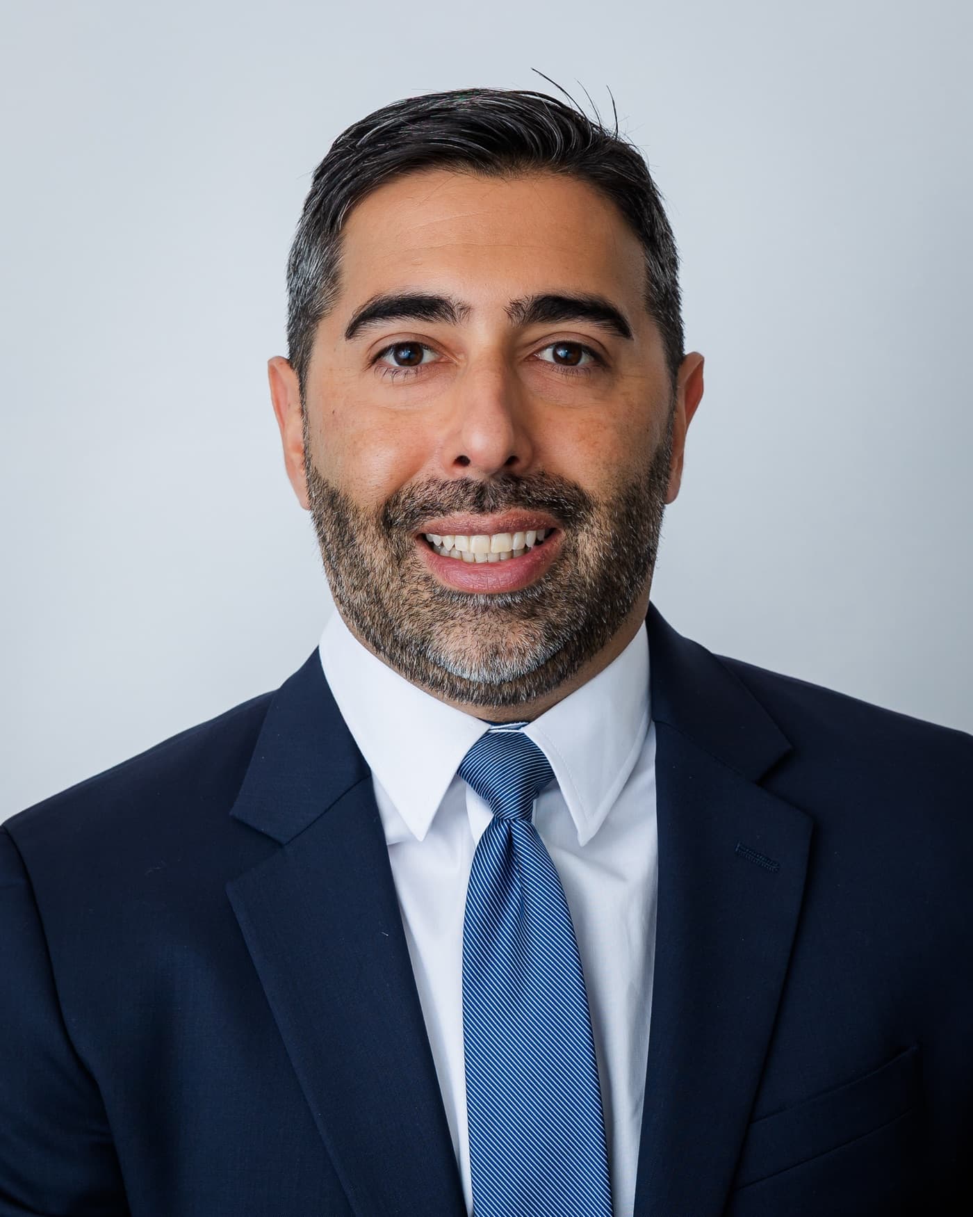 Paul M. Washburn, founder and principal of Sovereign Action, in a navy suit and blue tie against a pale studio background